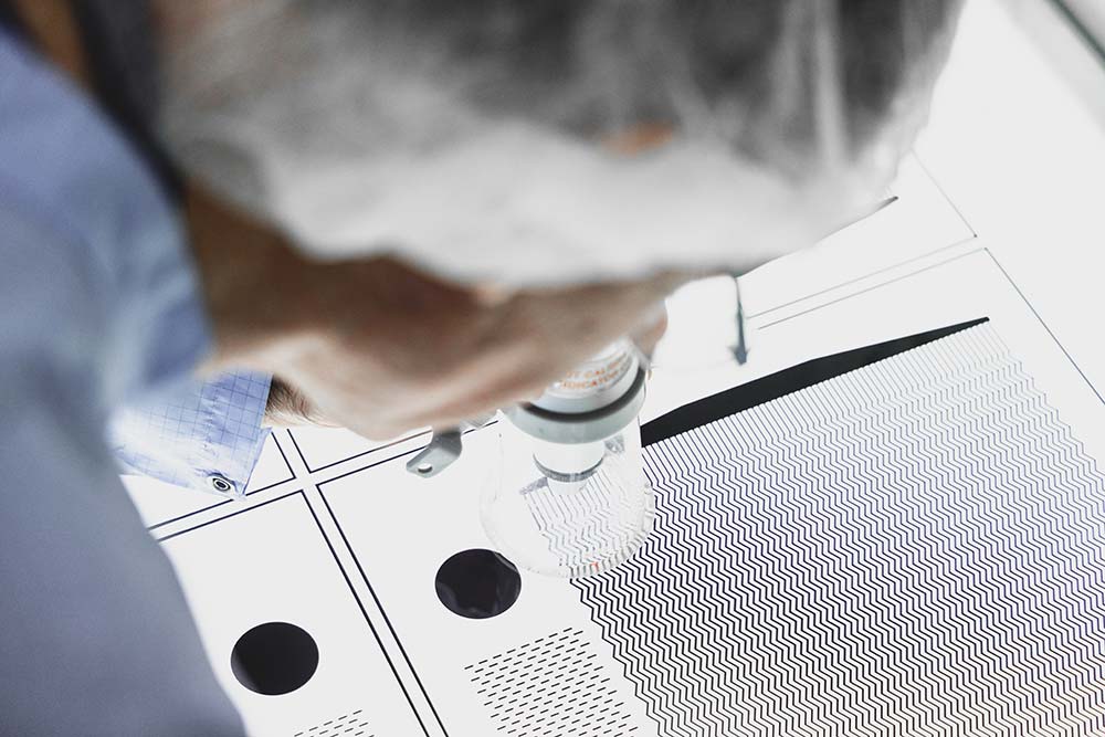 Man inspecting chemical etching phototool